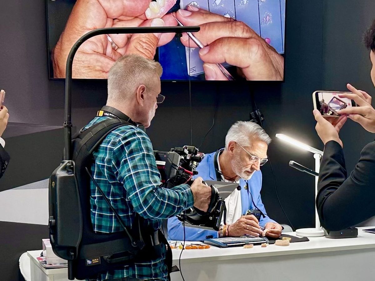 Carl filming a demonstration with an Easyrig, the shot relayed to a screen behind